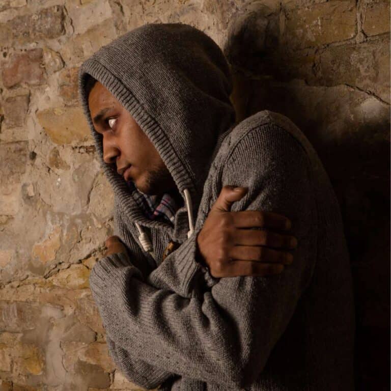   Drug addict posing near brick wall