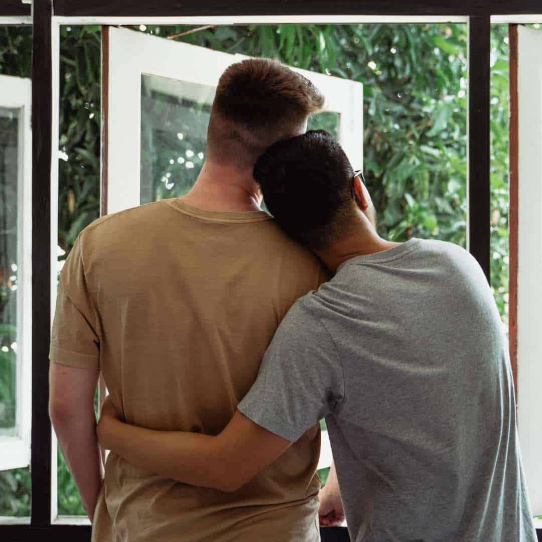   Couple-Hugging-Staring-out-Window-LGBTQIA-Addiction-Treatmentjpg