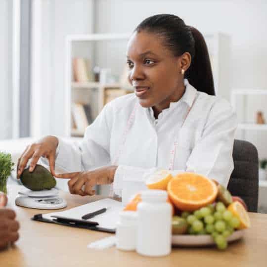   Eating Disorder Treatment Modalities Nutritionist Showing Healthy Diet To Patient